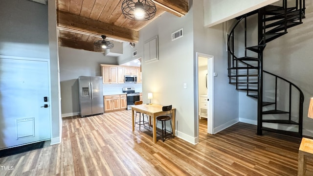 kitchen with wooden ceiling, light brown cabinets, stainless steel appliances, beam ceiling, and backsplash