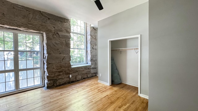 unfurnished bedroom featuring light hardwood / wood-style flooring, a closet, and ceiling fan
