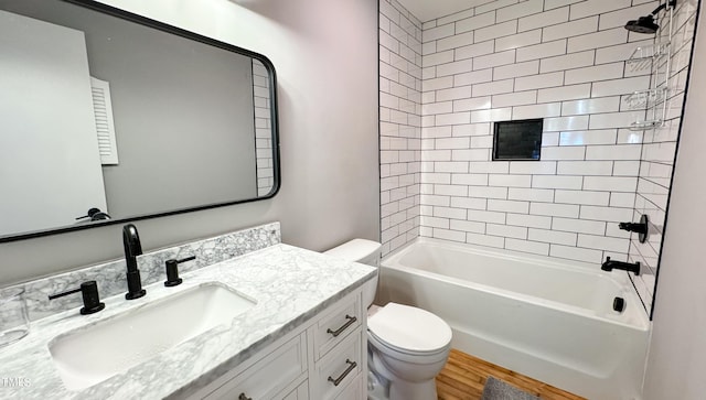 full bathroom featuring tiled shower / bath, vanity, toilet, and wood-type flooring
