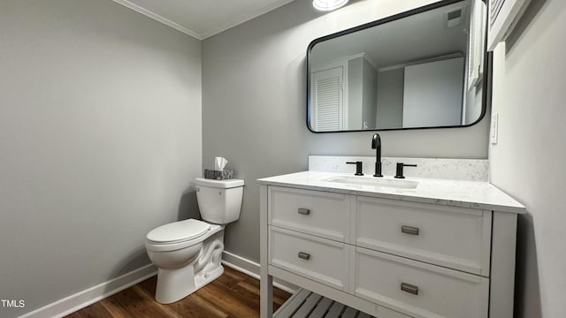 bathroom with vanity, crown molding, wood-type flooring, and toilet
