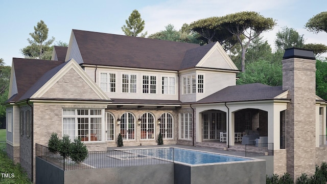 rear view of house with an outdoor pool, a patio, a chimney, french doors, and brick siding