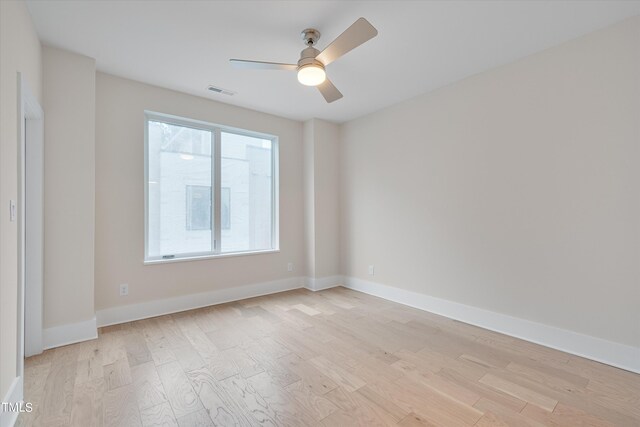 spare room featuring plenty of natural light, ceiling fan, and light hardwood / wood-style flooring