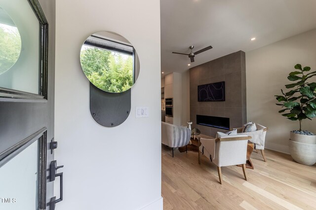 interior space featuring a fireplace, light hardwood / wood-style flooring, and ceiling fan