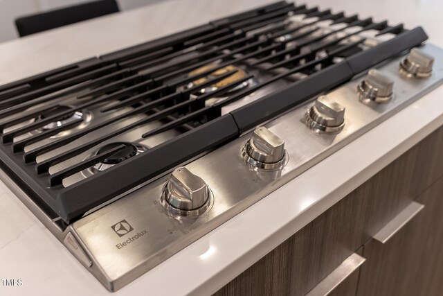 details featuring dark brown cabinets and stainless steel gas stovetop