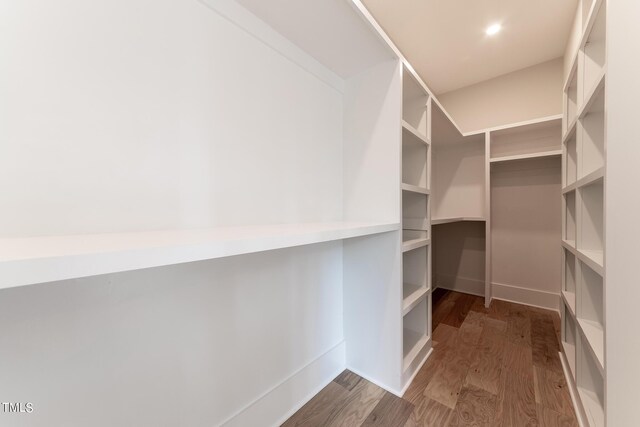 walk in closet with hardwood / wood-style flooring