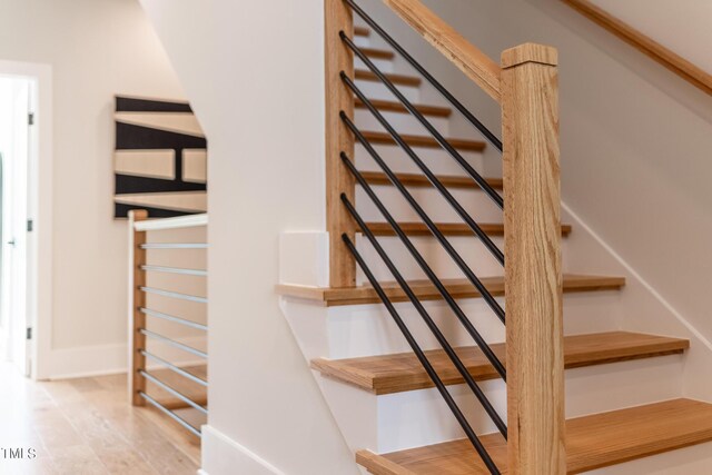 stairs featuring hardwood / wood-style floors