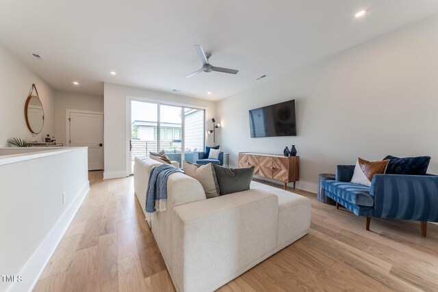 living room with ceiling fan and light hardwood / wood-style flooring