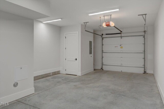 garage with a garage door opener and electric panel