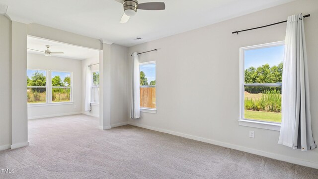 spare room featuring light colored carpet and ceiling fan