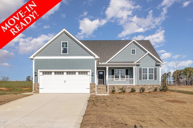 craftsman-style home with a garage, covered porch, and a front yard