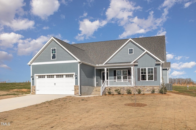 craftsman inspired home featuring covered porch, a garage, and central air condition unit