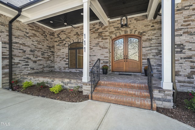 view of exterior entry featuring ceiling fan and covered porch