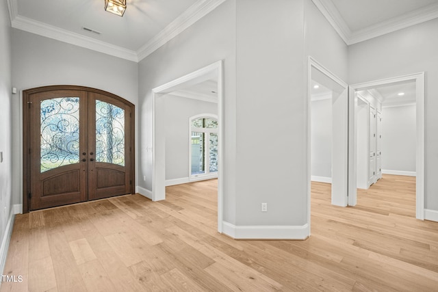 foyer featuring ornamental molding, light hardwood / wood-style floors, and french doors