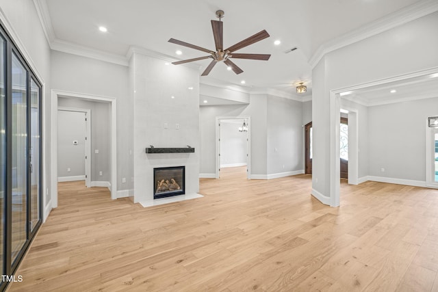 unfurnished living room featuring a large fireplace, light hardwood / wood-style floors, ceiling fan, and crown molding