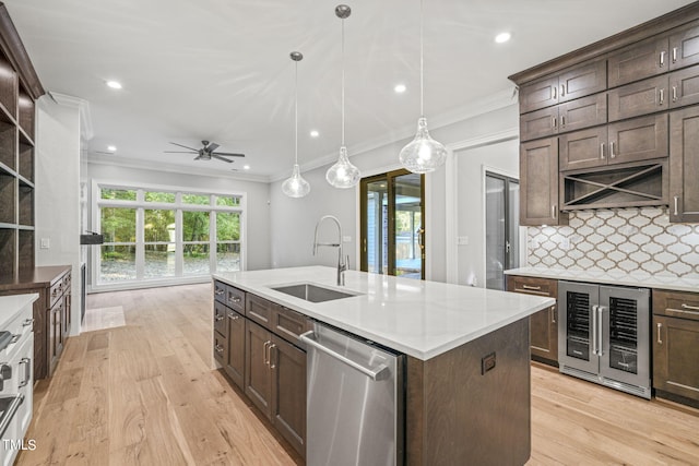 kitchen with sink, decorative light fixtures, a kitchen island with sink, dishwasher, and light wood-type flooring