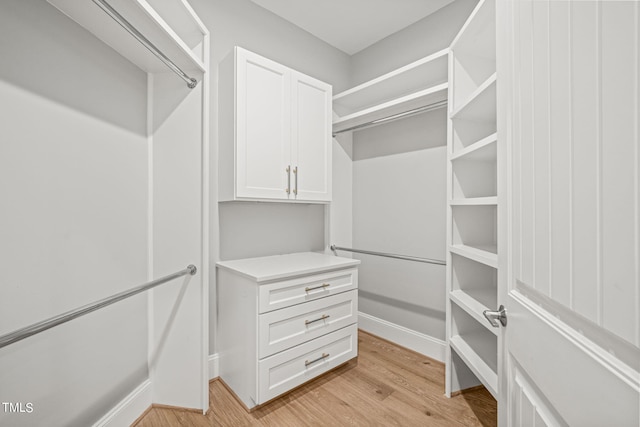 walk in closet with light hardwood / wood-style flooring