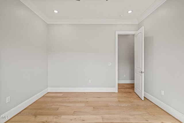 spare room with light wood-type flooring and crown molding