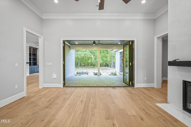 unfurnished living room featuring light wood-type flooring, ornamental molding, and ceiling fan