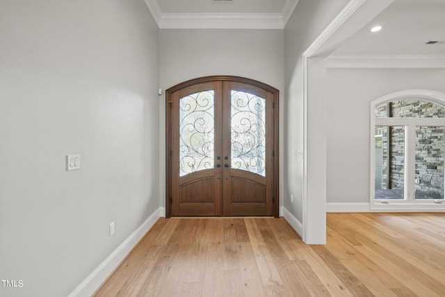 entrance foyer with french doors, light hardwood / wood-style flooring, and ornamental molding