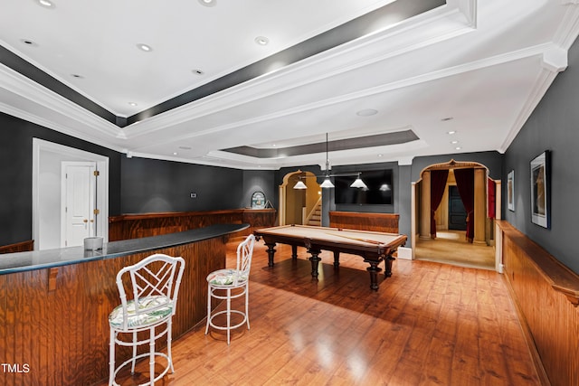 game room featuring ornamental molding, a raised ceiling, billiards, hardwood / wood-style floors, and bar