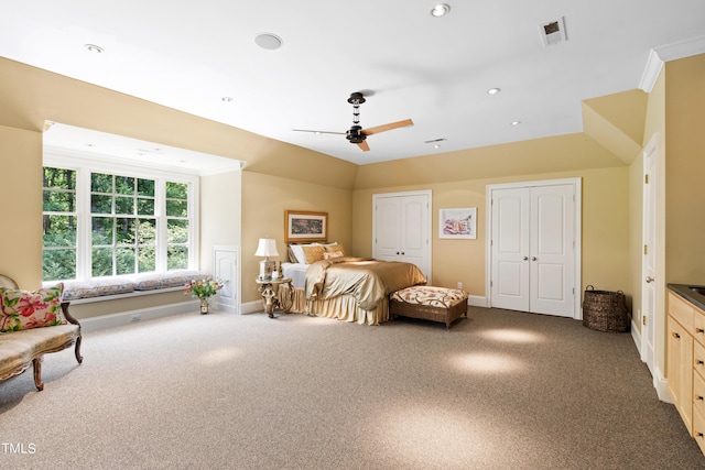 carpeted bedroom featuring multiple closets, ceiling fan, and lofted ceiling