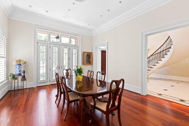 dining room with crown molding, dark wood-type flooring, and french doors