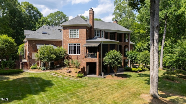 1820 Oatlands Ct, Wake Forest, NC 27587 - rear view of house with brick siding, a yard, a chimney, and a sunroom