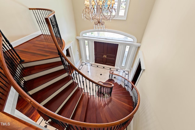 foyer entrance featuring tile patterned floors, a towering ceiling, and an inviting chandelier