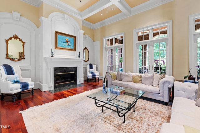 living room featuring french doors, coffered ceiling, ornamental molding, a fireplace, and beam ceiling