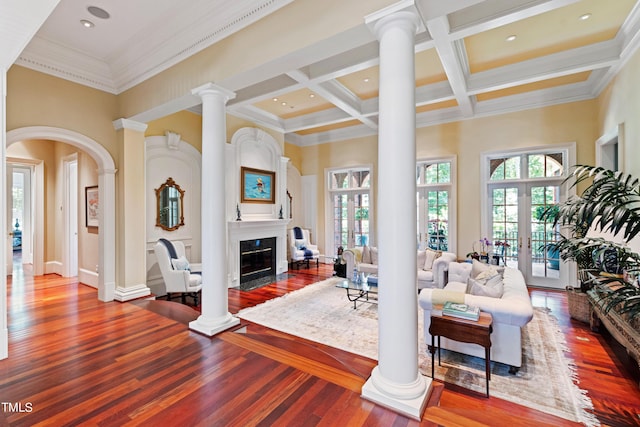 living room with beam ceiling, french doors, coffered ceiling, a towering ceiling, and ornamental molding