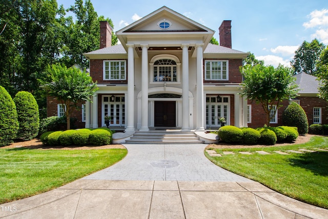 1820 Oatlands Ct, Wake Forest, NC 27587 - neoclassical / greek revival house with french doors, a chimney, a front lawn, and brick siding
