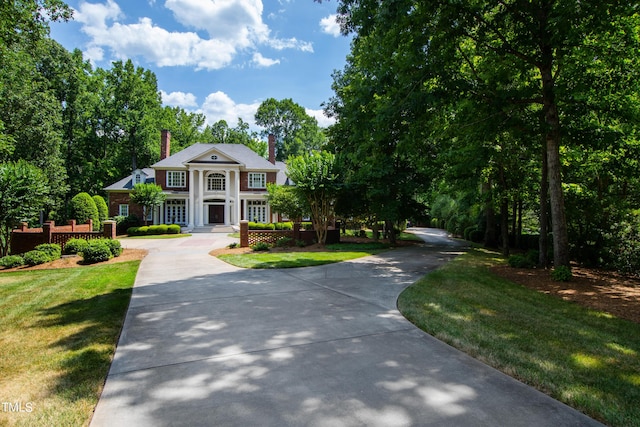 1820 Oatlands Ct, Wake Forest, NC 27587 - neoclassical home with a chimney, a front yard, and driveway