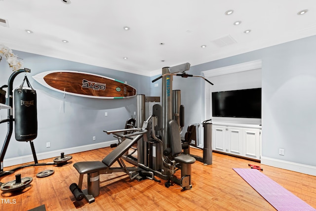 workout area with light hardwood / wood-style flooring