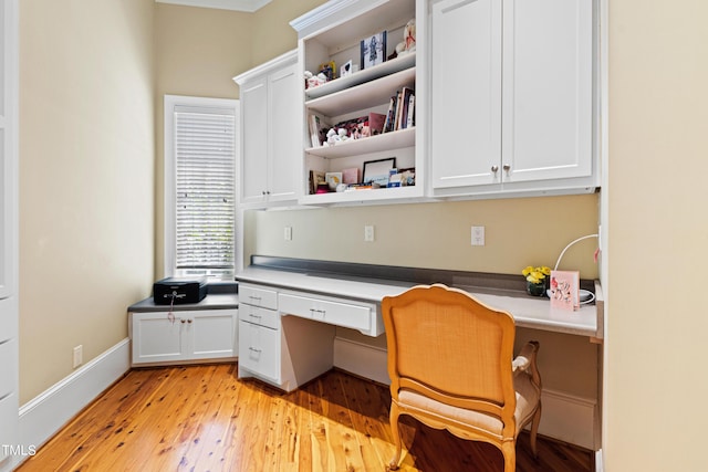 office area with built in desk and light hardwood / wood-style floors