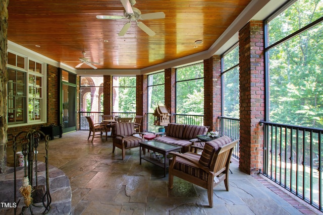 sunroom with ceiling fan and wooden ceiling