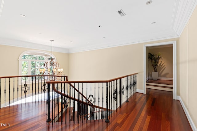 hallway featuring dark hardwood / wood-style flooring, crown molding, and a notable chandelier