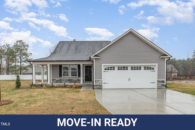 view of front of home with a garage, a front yard, and a porch