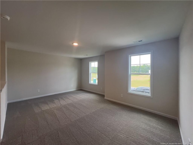 spare room with dark carpet