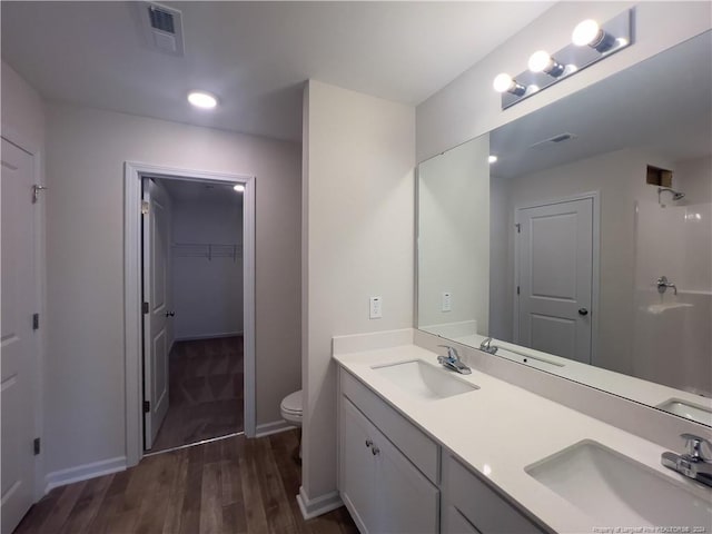 bathroom with hardwood / wood-style floors, vanity, and toilet