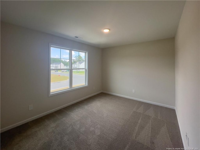 unfurnished room with dark carpet