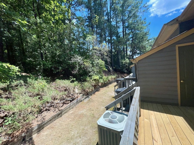 view of yard with central AC and a wooden deck