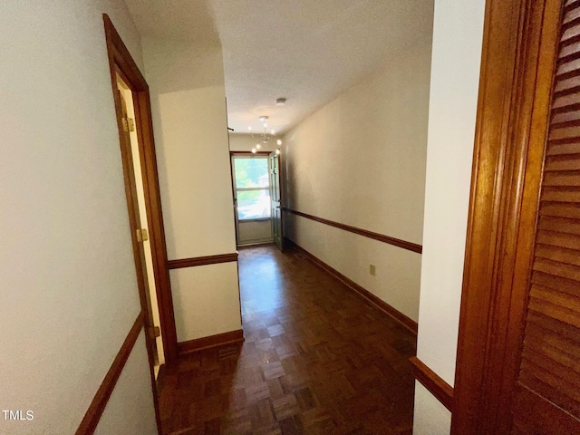 corridor featuring dark parquet flooring