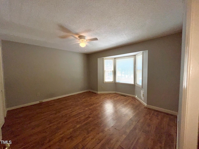 unfurnished room with ceiling fan, dark hardwood / wood-style flooring, and a textured ceiling