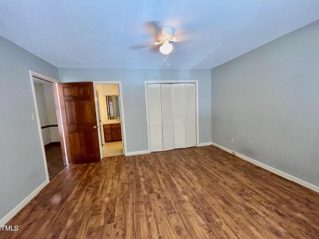 unfurnished bedroom with connected bathroom, hardwood / wood-style flooring, a closet, and ceiling fan