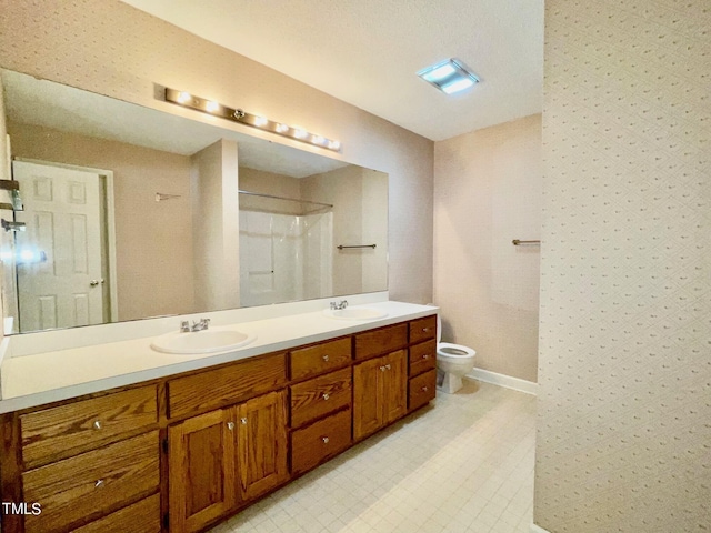 bathroom featuring vanity, toilet, and a shower