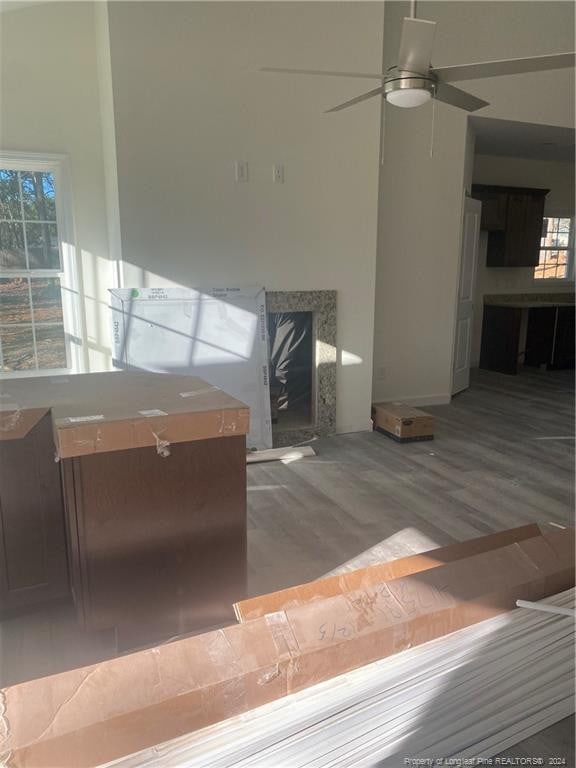 unfurnished living room featuring a fireplace, ceiling fan, and hardwood / wood-style floors