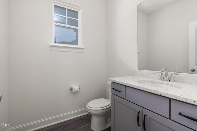 bathroom with vanity, toilet, and hardwood / wood-style flooring