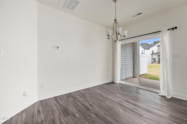 unfurnished dining area with dark hardwood / wood-style flooring and an inviting chandelier