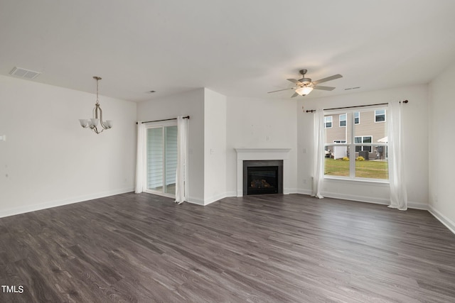 unfurnished living room with dark wood-type flooring and ceiling fan with notable chandelier