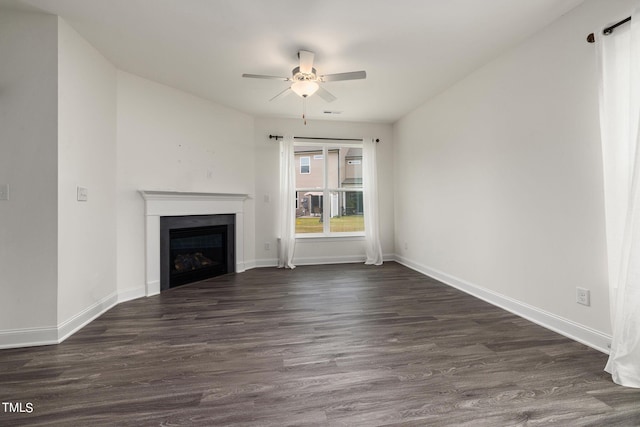 unfurnished living room featuring ceiling fan and dark hardwood / wood-style floors